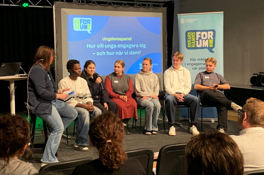 Kommunikatör Maria Roth på scen tillsammans med sex ungdomar i en panel