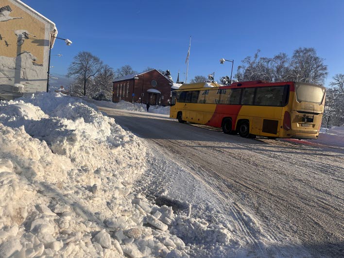 Buss med snöhög i förgrunden