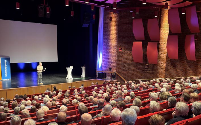 Man på scen framför fullsatt publik