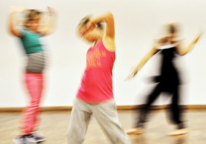 En suddig bild på tre barn som dansar.