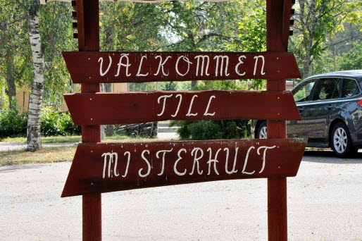 Träskylt med texten Välkommen till Misterhult.