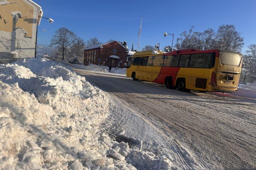 Buss med snöhög i förgrunden