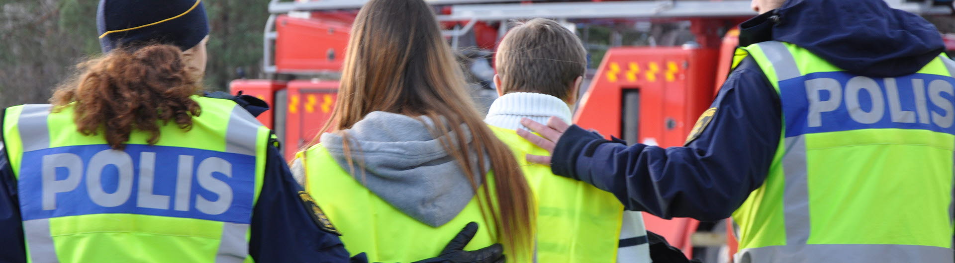 Två poliser tar hand om två ungdomar.