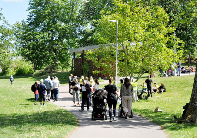 En grupp människor som deltar i sommarfesten i stadsparken.