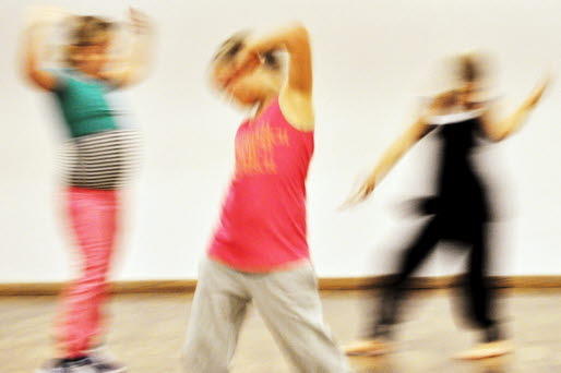 En suddig bild på tre barn som dansar.