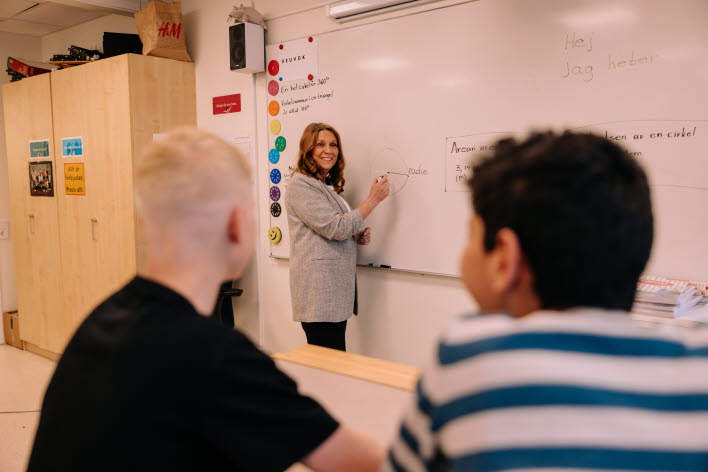 lärare skriver på tavla