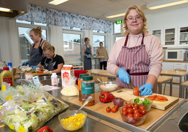Några ungdomar lagar mat i skolan.