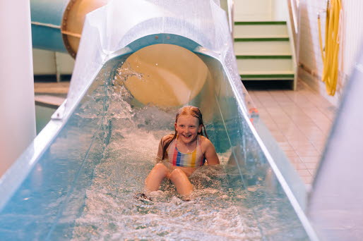 En flicka åker nedfäör en vattenrutschkana.