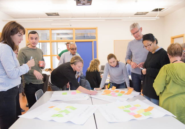 Homo sapiens sapiens som står runt ett bord