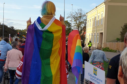 Prideparad med kommunflagga i förgrunden
