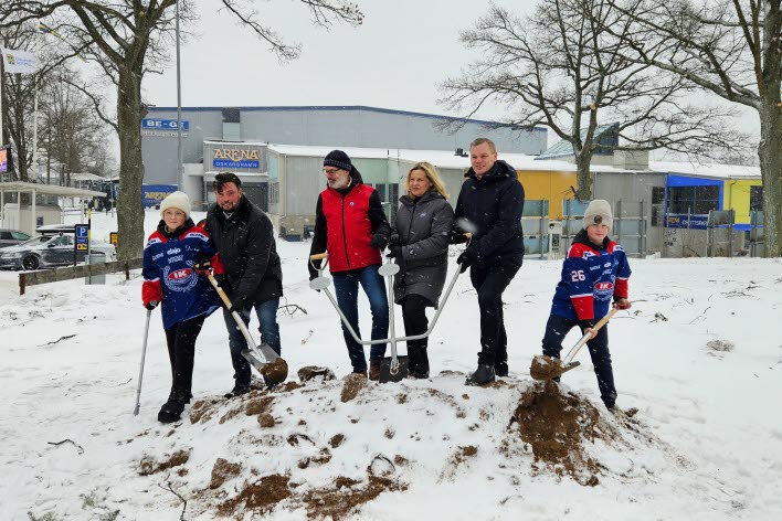 Sex personer tar ett gemensamt spadtag i en grushög, på platsen där den nya träningsishallen ska byggas. 