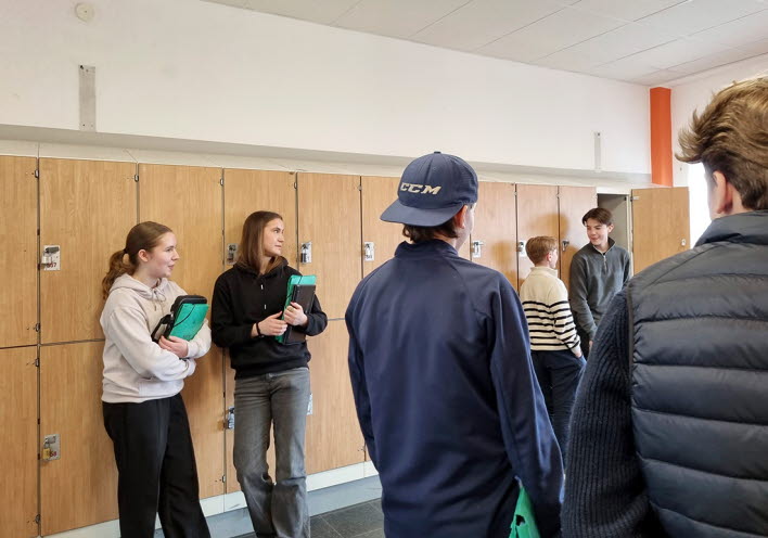 En grupp grundskoleelever umgås i skolkorridoren.