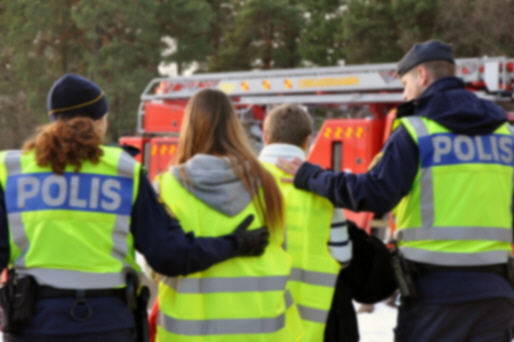 Två poliser leder två barn.