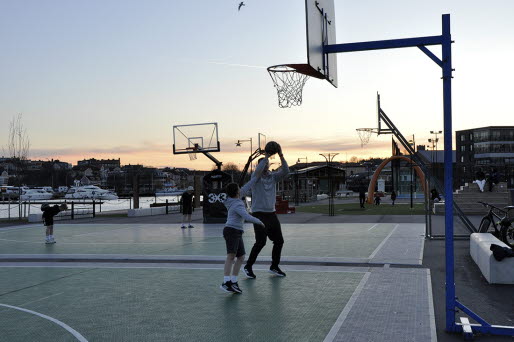 En pojke och hans pappa spelar basket utomhus.