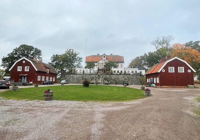 Exteriör av huset med Fredriksbergs herrgård i bakgrunden.