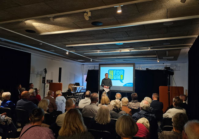 Moderator Kristoffer Malm står framför publik