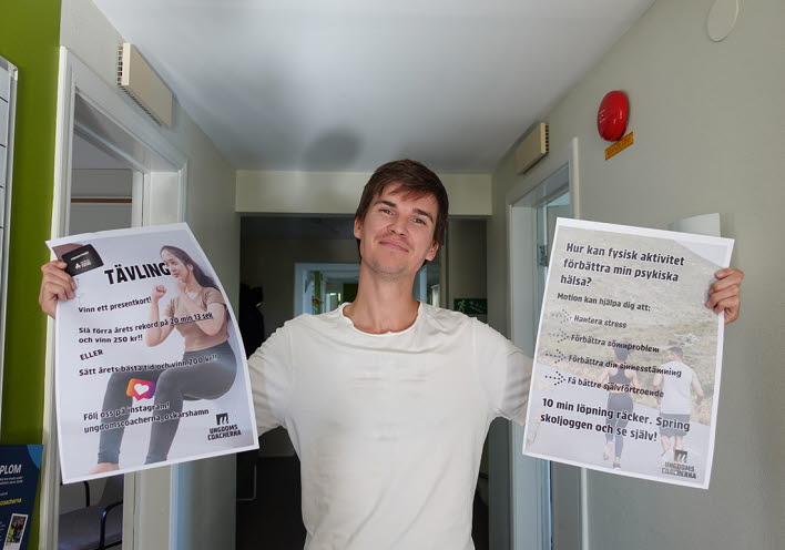 Martin håller i två affischer.