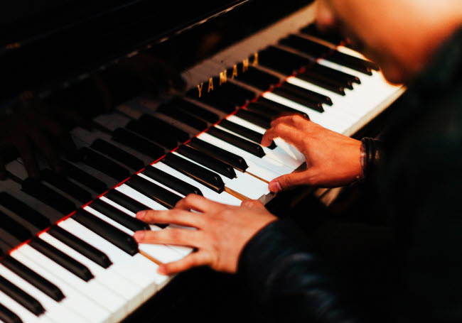 Närbild på händer som spelar piano.